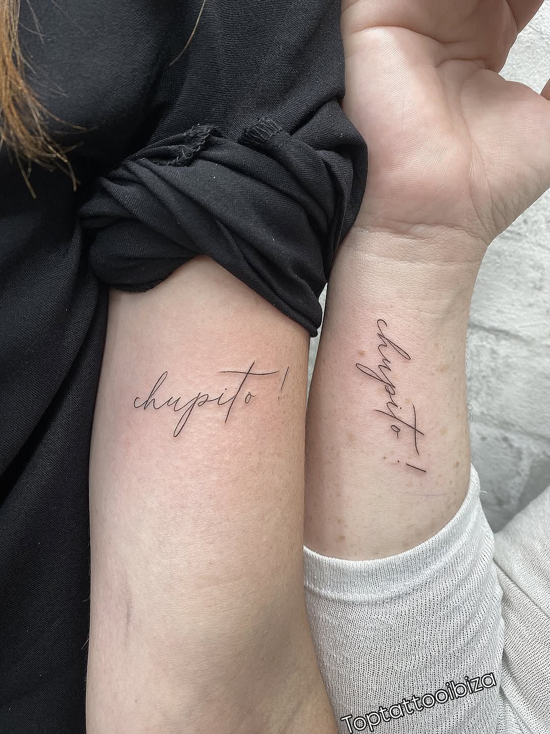 Matching 'chupito!' fine-line script tattoos on two wrists
